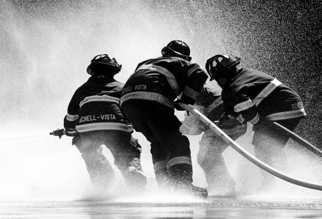 pexels-photo-266403-266403 Firefighters in full gear battle heavy water spray in an intense operation.